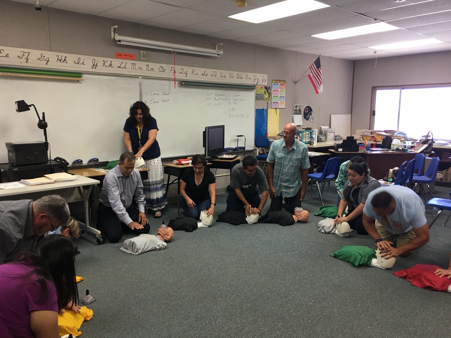 Participants practicing CPR on training manikins in a classroom